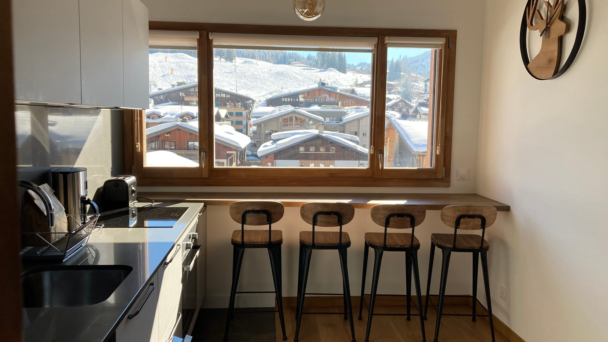 La cuisine ouverte avec vue sur le village enneigé et les pistes de ski